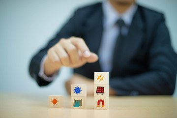 Hand arranging wood block stacking with icon Energy for earth, Saving Energy concept -