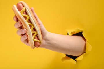 Hand taking a hot dog
