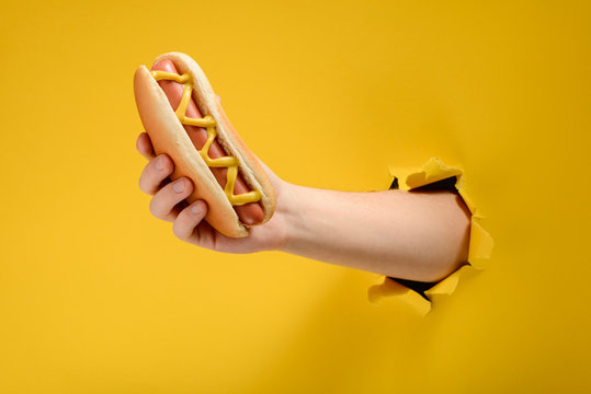 Hand taking a hot dog