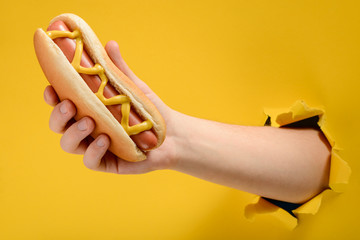 Hand taking a traditional hotdog