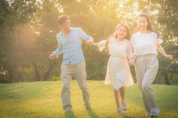 Naklejka na ściany i meble Portrait image of Family and kid have fun together in the garden in sunset. Concept family love.