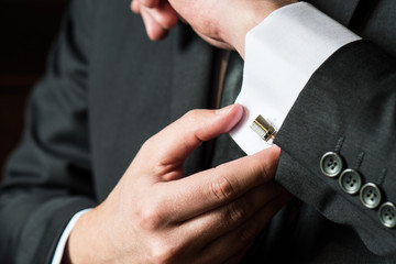 Close up of a man fixing his cuff-links