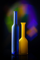 two bottles minimalism, blue and yellow bottles on dark background with multicolor lights, bright colors