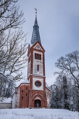 Fototapeta na wymiar Krimulda Evangelical Lutheran Church on the hill in the wintertime. Krimulda, Latvia. Facade.