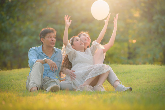 Portrait image of Family and kid have fun together in the garden in sunset. Concept family love.