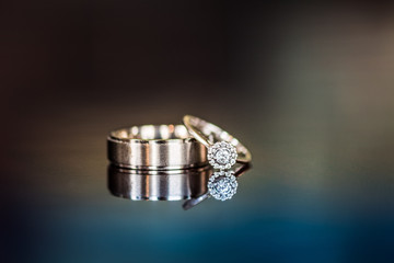 Wedding rings on a reflective surface.