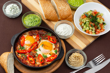 shakshuka in the pan and food on a table