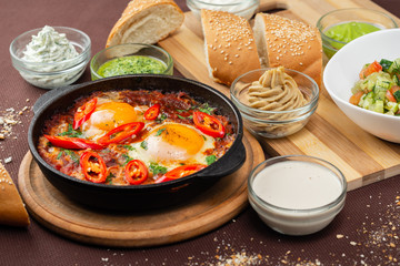 shakshuka in the pan and food on a table