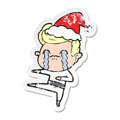 distressed sticker cartoon of a man crying wearing santa hat