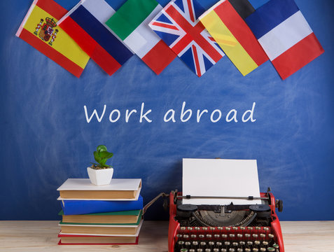 typewriter, flags of Spain, France, Great Britain, books and other countries and blackboard with text "Work abroad"