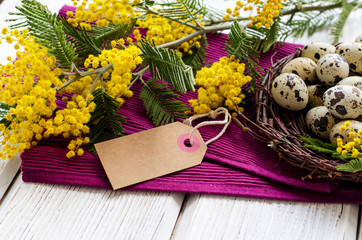 Easter eggs and Mimosa flower on a wooden backgraund. Space for text. - Image