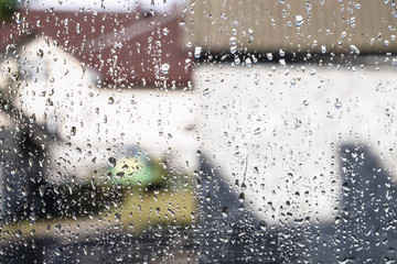 Beautiful raindrops on the window glass. Spring summer weather with warm rain. Stock photo