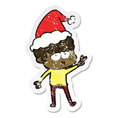 distressed sticker cartoon of a exhausted boy wearing santa hat