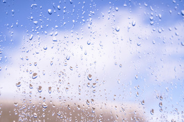 Beautiful raindrops on the window glass. Spring summer weather with warm rain. Stock photo