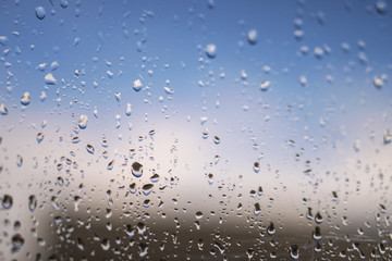 Beautiful raindrops on the window glass. Spring summer weather with warm rain. Stock photo