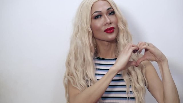 Close-up shot of a beautiful transgender woman making a heart symbol her hands