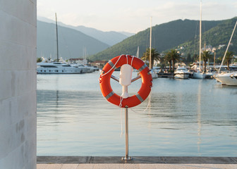 Lifebuoy in the harbor on the pier near the water