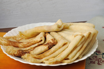 Several homemade pancakes on a white plate. Close-up.