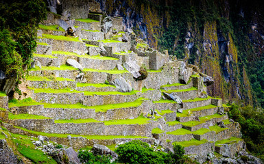 Amazing scenery of majestic ancient stone Machupicchu temple covered with grass on the background of rocky mountain