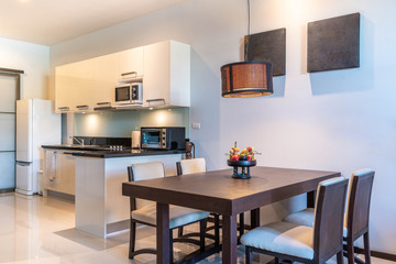 Luxury interior design pool villa in kitchen area which feature island counter and built in furniture in living room of the house or home building 