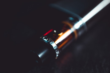 Vape pen metal electronic cigarette with vaping dark background