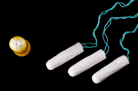 Menstrual period concept. Woman hygiene protection. Cotton tampons on black background. Top view, flat lay