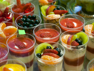 Fototapeta na wymiar Healthy food on display, ripe fruit and yogurt, small portions in cups