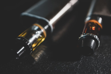 Vape pen metal electronic cigarette with vaping dark background