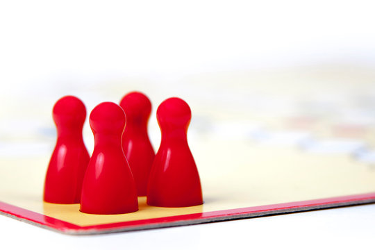 Four Red Game Pieces On A Game Board