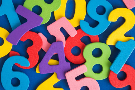 Close up of multicolored wooden numbers back to school abstract.