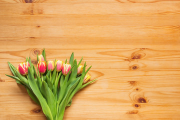 Bouquet of tulips on a wooden table, background