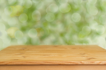 Wooden table with blurred green background