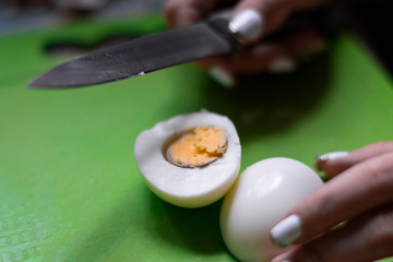 Cut an egg in half. Chicken egg and knife
