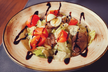 meat, egg, lettuce, tomatoes and cheese salad in white plate, selective focus