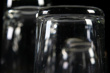 Close up of three different empty shot glasses on black background.