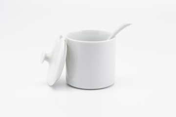 A mini white bowl with spoon and open cover in set