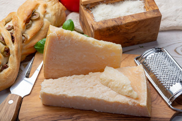 Original italian cheese, aged Parmesan cow milk cheese, pieces and grated Parmigiano-Reggiano