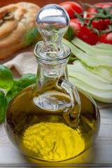 Obraz na płótnie Canvas Virgin natural olive oil is glass bottle, served with traditional Mediterranean food