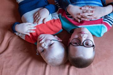 Caucasian blond children in glasses for sight with strong diopters posing in front of camera....
