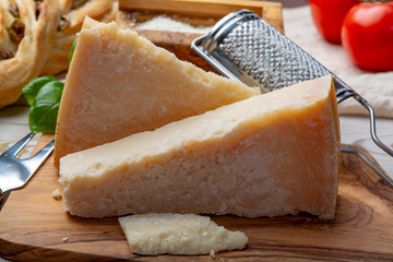 Original italian cheese, aged Parmesan cow milk cheese, pieces and grated Parmigiano-Reggiano