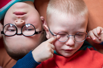 Caucasian blond children in glasses for sight with strong diopters posing in front of camera. Children go to school for visually impaired teens. Teens are friends and happy together