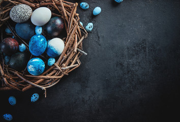 Colored eggs and paint on a dark table, Easter background