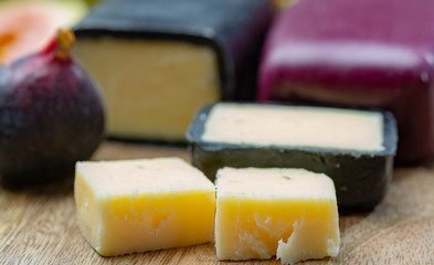 Mini black and dark red waxed cheddar cheeses made from West Country milk and and age-old methods in England