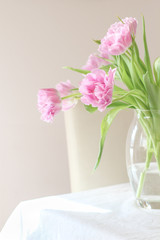 Fototapeta na wymiar Pink tulips in a vase on a dinning table