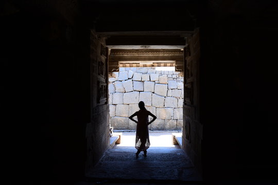 Silhouette of woman against rock wall