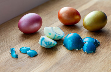 Fototapeta na wymiar peeled dyed easter egg with traces of dye on egg white among other easter eggs, food dye safety