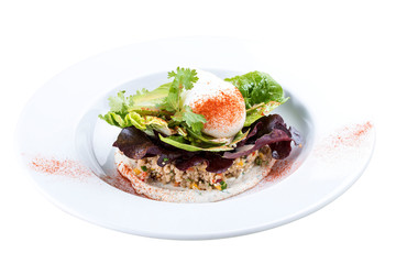 Poached egg with quinoa and salad on a white plate