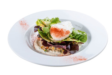 Poached egg with quinoa and salad on a white plate