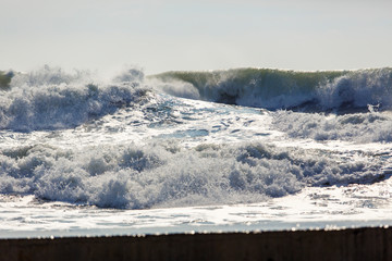 Strong and dangerous storm in the Black sea. Beautiful and large storm surge in the Bay of Gelendzhik in Gelendzhik. sea foam, wave crests, clear green water. 