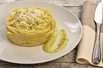 pasta lunga arrotolata con crema di broccoli e formaggio parmigiano primo piano